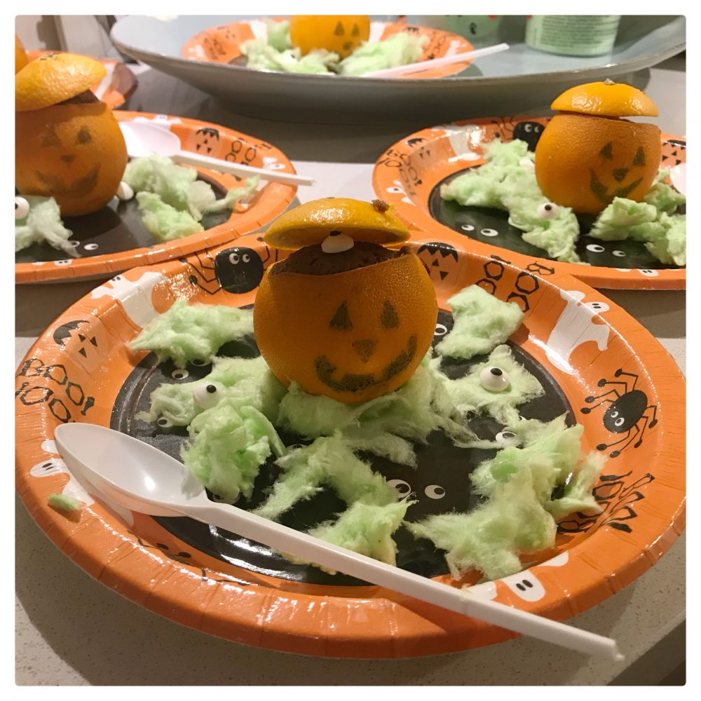 3 orange paper plates with satsumas- that have been decorated to look like pumpkins