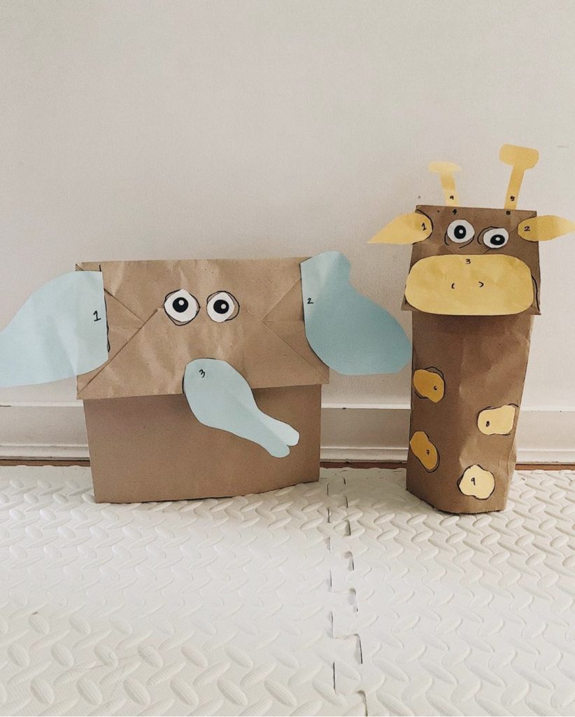 A photo of a brown paper bag elephant and a brown paper bag giraffe