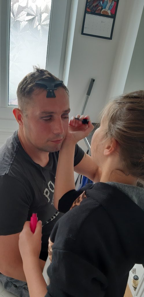 A photo of a girl putting make up on a man