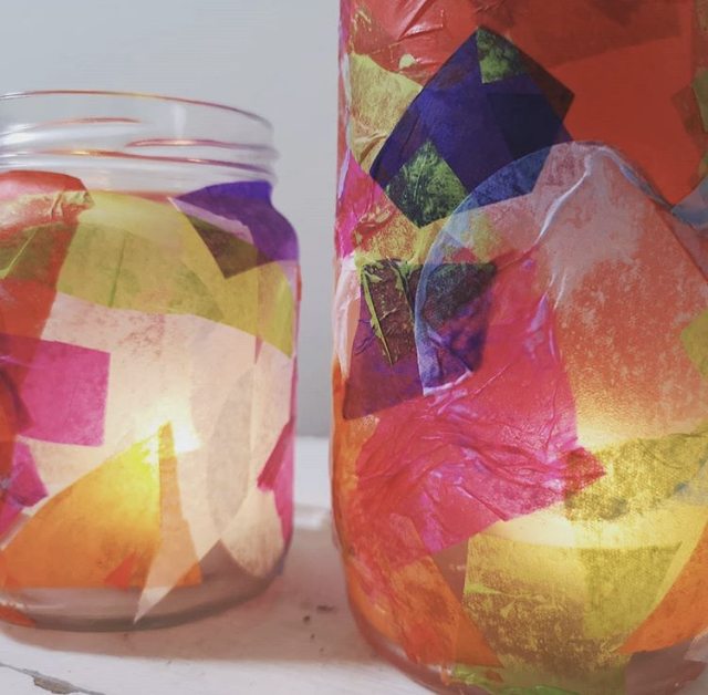 A photo of 2 glass jars with colourful paper stuck on them 