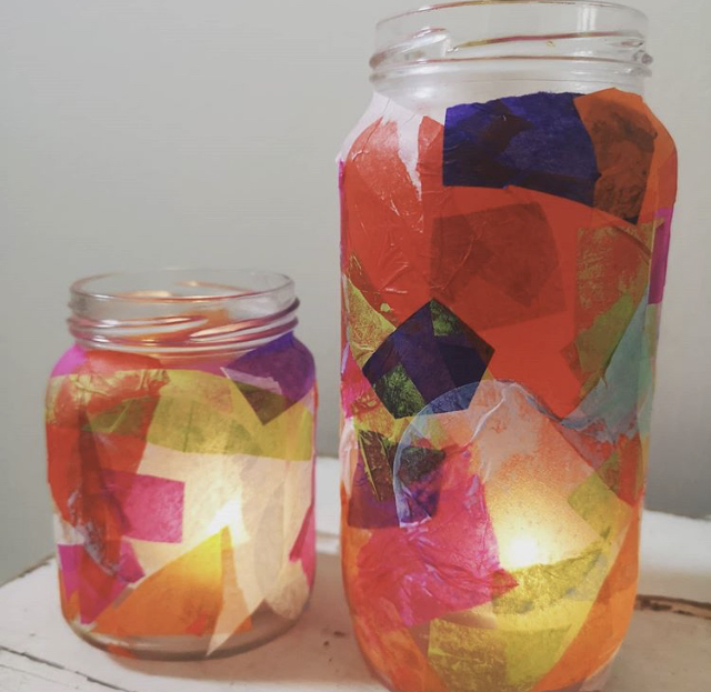 A photo of 2 glass jars with colourful paper stuck on them 