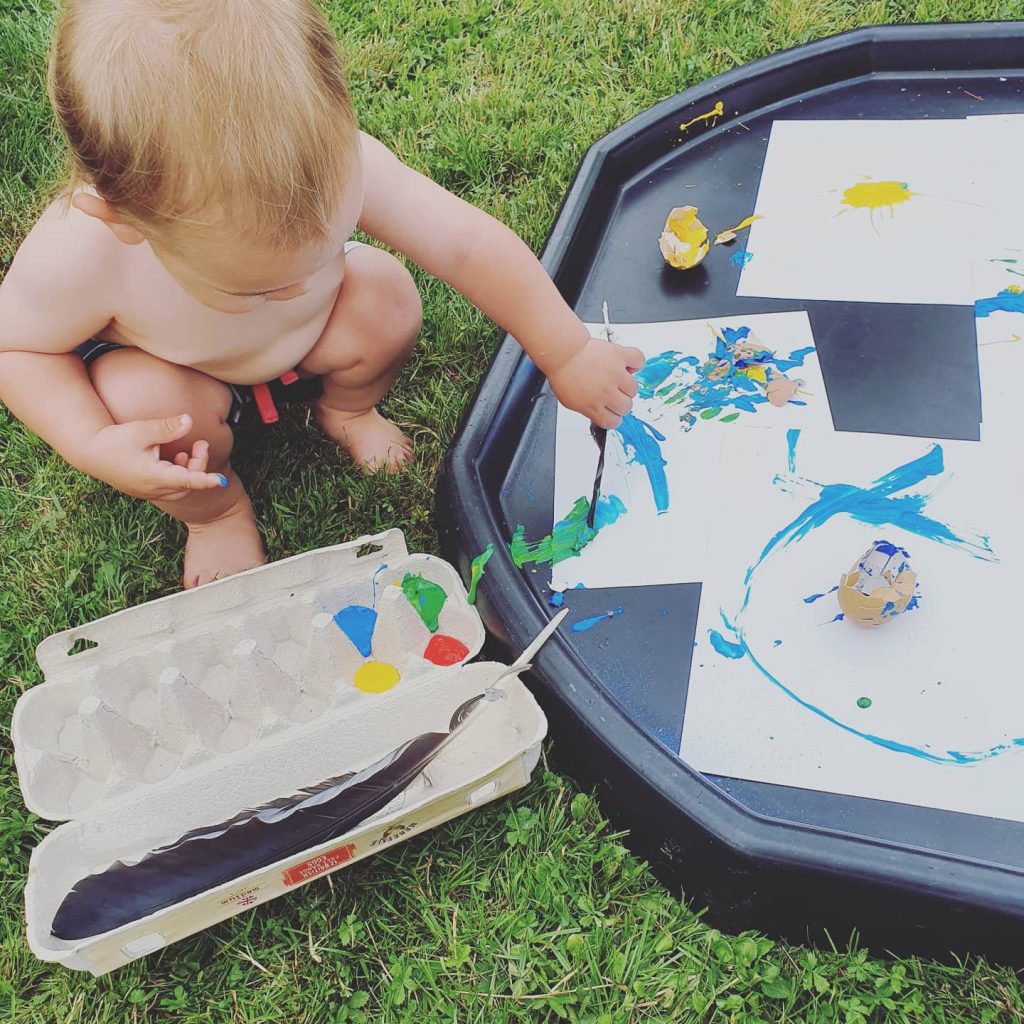 a photo of a child painting in the garden 