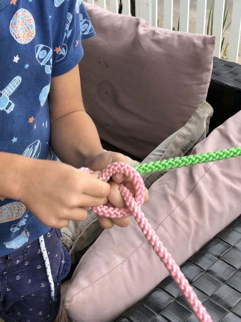 a photo of a pink and green rope that are being tied together