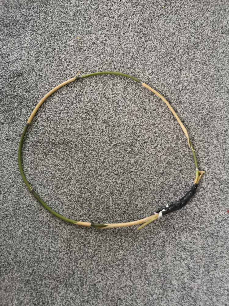 a photo of a bamboo stick that has been sellotaped into a circle