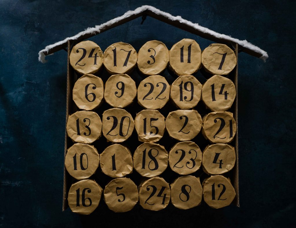 A photo of an advent calendar, with numbers written on golden paper